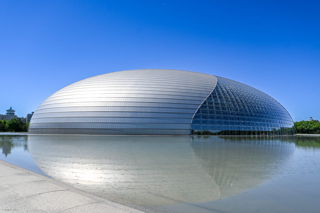 The National Centre for the Performing Arts, also known as The Giant Egg, is an iconic feature of Beijing's cultural landscape. Designed by French architect Paul Andreu, this arts complex was completed in 2007 and is renowned for its distinctive ellipsoid dome of titanium and glass, surrounded by an artificial lake.